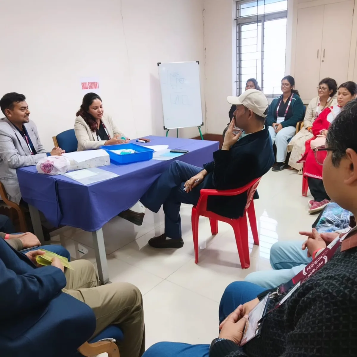 Dr. Swathi Rao teaching delegates seated around the Skill Station 1 table at Pedicon 2026