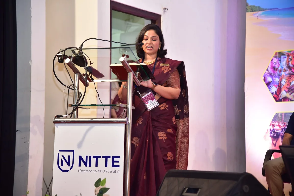 Dr. Swathi Rao speaking at a lectern at a Nitte conference