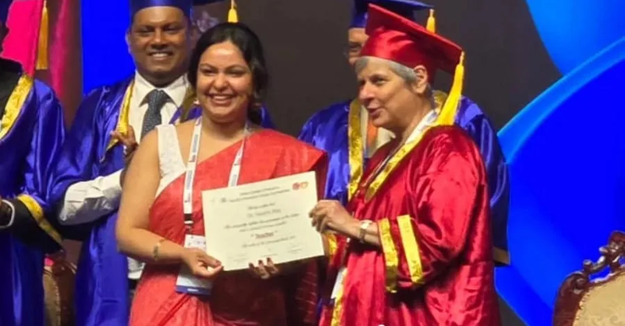 Dr. Swathi Rao receiving a Teacher accreditation certificate on stage