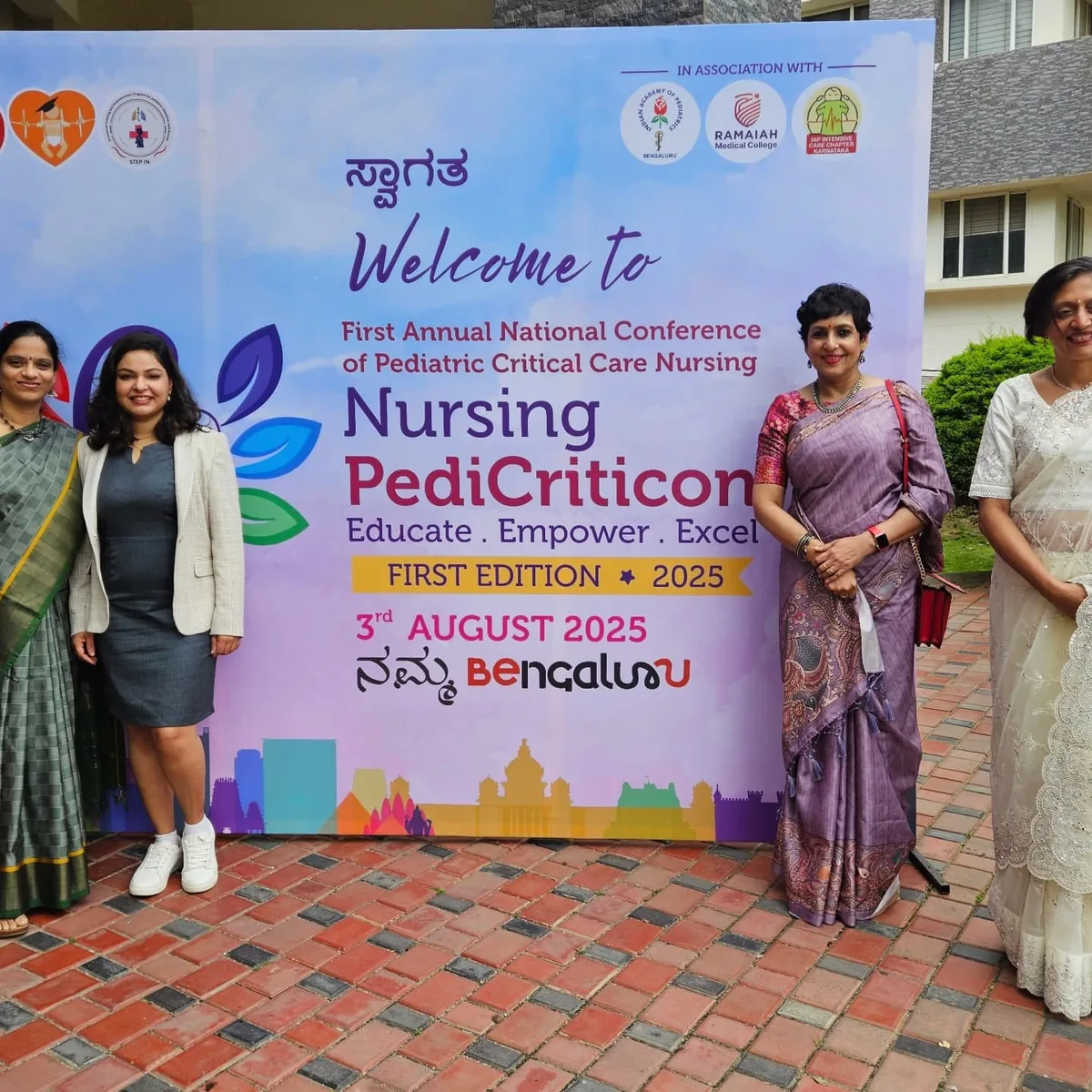 Dr. Swathi Rao with colleagues at the Nursing PediCriticon 2025 welcome banner in Bengaluru
